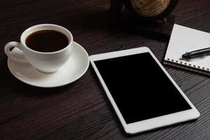 tablet e xícara de café e caderno em branco para memorando foto