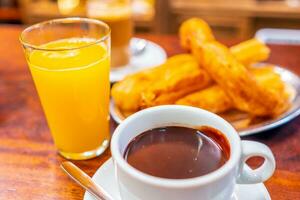 típica espanhol churros servido com copo do quente chocolate dentro sevilha, Espanha foto