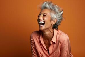 Senior mulher rindo cordialmente isolado em uma queimado Sienna gradiente fundo foto