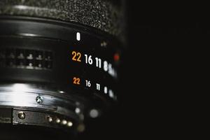 lente da câmera com números de abertura em um fundo preto foto