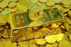 bitcoin criptomoeda na barra de ouro e pilha de moedas de ouro foto