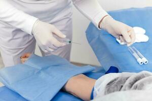 laboratório trabalhador médico leva uma sangue amostra para análise, mão fechar-se. sangue amostragem dentro a laboratório. levando uma sangue dentro cosmetologia clínica antes prp terapia procedimento foto