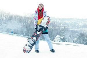 jovem mulher segurando snowboard em dela ombros foto