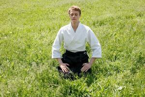 fechar acima retrato do jovem taekwondo homem exercício foto