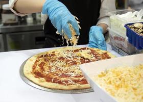 chef preparando pizza, chef processo de fazer pizza em pizzaria foto