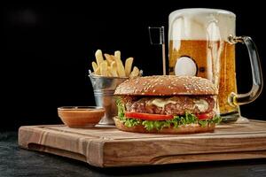 hamburguer com carne empada, azul queijo, caramelizado cebola, fresco legumes servido com pálido cerveja, fritas e molho foto