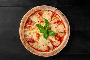 pizza margherita com pelati molho, mussarela, tomates e manjericão foto