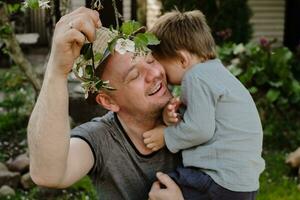 pai e pequeno filho apreciar Primavera gastar Tempo juntos ao ar livre. família afeição conceito. foto