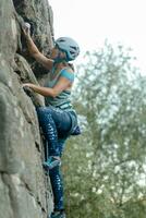 uma menina sobe uma Rocha. mulher acionado dentro extremo esporte. foto