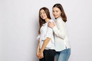 dois rindo meninas dentro branco em branco Camisetas olhando para dentro a Câmera foto