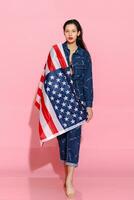 retrato fêmea atleta embrulhado dentro americano bandeira contra Rosa fundo foto