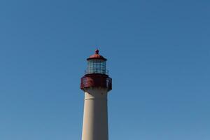 isto é a topo imagem do capy pode ponto farol. a vermelho metal topo carrinhos Fora contra a branco tijolo do a torre. foto