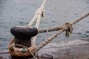 uma corda amarrado para uma barco em a doca foto