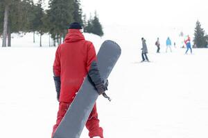 snowboarder dentro capacete em pé às a muito topo do uma montanha foto