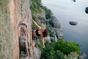 uma menina sobe uma Rocha. mulher acionado dentro extremo esporte. foto