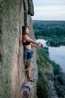 uma menina sobe uma Rocha. mulher acionado dentro extremo esporte. foto