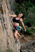 uma menina sobe uma Rocha. mulher acionado dentro extremo esporte. foto