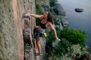 uma menina sobe uma Rocha. mulher acionado dentro extremo esporte. foto