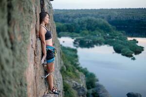 uma menina sobe uma Rocha. mulher acionado dentro extremo esporte. foto