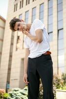 bonito jovem hipster à moda homem dentro branco camisa, Preto calça foto