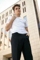 bonito jovem hipster à moda homem dentro branco camisa, Preto calça foto