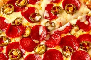 peças do Pimenta jalapeno em topo do picante calabresa pizza com derretido mozzarella foto