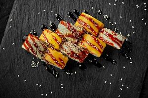 uramaki rolos embrulhado dentro queijo cheddar e enguia com unagi molho e sésamo foto