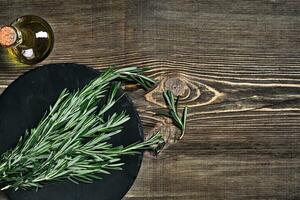 galhos do alecrim em cinzento de madeira mesa. alecrim em corte borda. rústico estilo, fresco orgânico ervas. foto