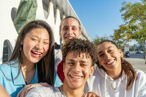 grupo do feliz Adolescência amigos levando uma selfie e rindo dentro a cidade rua Visão a partir de a Câmera. foto