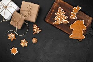Natal composição. natal biscoitos, presentes, festivo decoração em Preto fundo. plano deitar, topo visualizar, com cópia de espaço. foto