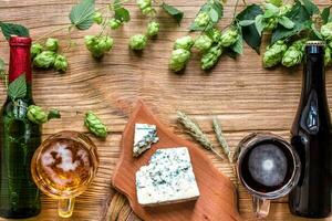 Cerveja fundo. fresco Cerveja e a salgado queijo em uma de madeira mesa. topo Visão foto