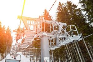 esqui lift às esqui recorrer Bukovel dentro a montanhas em uma ensolarado inverno dia. Sol flare foto