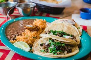 tradicional mexicano tacos com carne bovina, arroz e legumes em prato foto