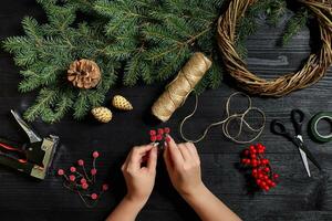 fabricante do Natal decoração com seus próprio mãos. Natal guirlanda para a feriado. a Novo ano celebração. topo Visão foto