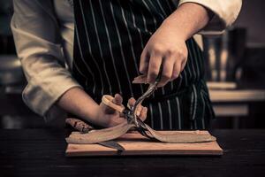 chefe de cozinha corte a peixe em uma borda foto