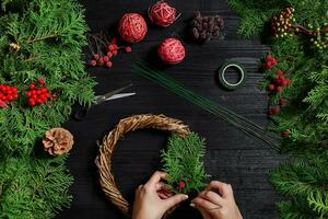 fabricante do Natal decoração com seus próprio mãos. Natal guirlanda para a feriado. a Novo ano celebração. topo Visão foto