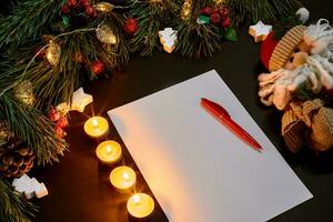 vermelho Natal bolas e caderno deitado perto verde abeto ramo em Preto fundo topo visualizar. espaço para texto foto