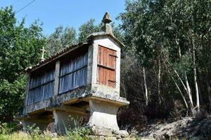 a velho limitar de madeira construção em a lado do uma Colina foto