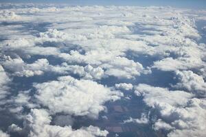 pesado branco cinzento nuvens a partir de a Visão em uma avião, com azul céu e luz do sol. foto