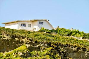 uma casa em uma encosta com uma verde gramado foto