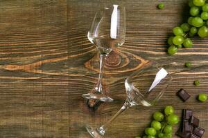 óculos do vinho e maduro uvas isolado em uma de madeira mesa foto