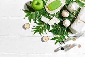 spa conjunto com toalha e Sabonete em branco de madeira fundo com verde folhas foto