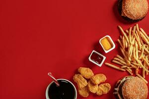 hamburguer e salgadinhos. Hamburger e francês fritas dentro vermelho papel caixa. velozes Comida em vermelho fundo. foto