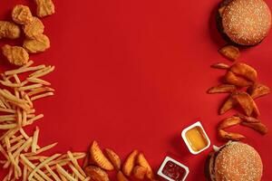 hamburguer e salgadinhos. Hamburger e francês fritas dentro vermelho papel caixa. velozes Comida em vermelho fundo. foto