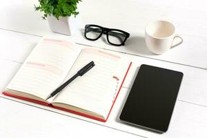 à moda minimalista local de trabalho com tábua e caderno e óculos dentro plano deitar estilo. branco fundo. foto