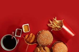 hamburguer e salgadinhos. Hamburger e francês fritas dentro vermelho papel caixa. velozes Comida em vermelho fundo. foto