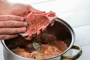 fechar acima do chefs mãos tempero a carne foto