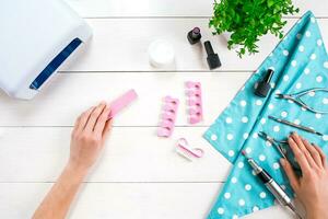 mulher mãos Cuidado. topo Visão do lindo suave mulher mãos com profissional unha Cuidado Ferramentas para manicure em branco fundo. foto