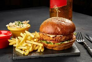 saboroso hambúrguer, francês fritas com molho e vidro do Cerveja em Preto borda foto