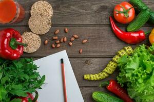 vidro do tomate suco com legumes e medindo fita em mesa fechar-se foto